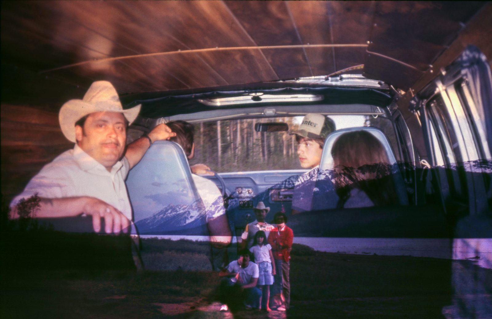 The artist’s grandfather in a cowboy hat inside a van, overlapping the family standing small beside a mountain lake.